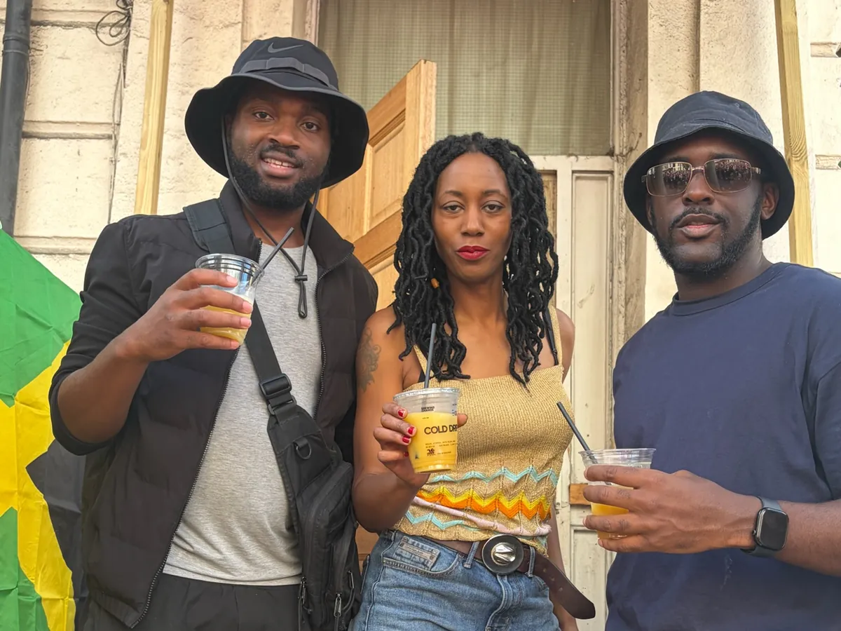 Three friends raise cups of Brewing Change Cold Drip on a sunny London street